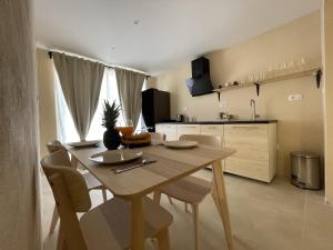 kuchnia i jadalnia z drewnianym stołem i krzesłami w obiekcie Cozy apartment Matijas with private parking and terrace w Splicie