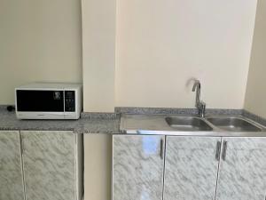 a kitchen counter with a microwave and a sink at Abdullah Kamber Building in Dubai