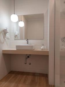 a bathroom with a sink and a mirror at Estúdio Lagoa Azul in Vila Nova de Milfontes