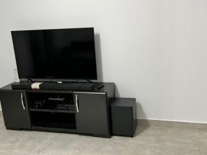 a flat screen tv sitting on top of a black entertainment center at شاليه بالميرا العين السخنة للعائلات فقط in Ain Sokhna