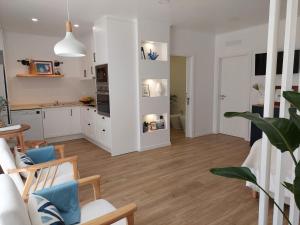 a kitchen and living room with white cabinets at Estúdio Lagoa Azul in Vila Nova de Milfontes