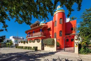 un edificio rojo con una torre en la parte superior en Casa Rodeo - Golden Zone Villa with Large Pool & Rooftop Ocean Views, en Bucerías
