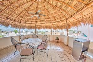 un patio con mesa y sillas bajo un techo de paja en Casa Rodeo - Golden Zone Villa with Large Pool & Rooftop Ocean Views, en Bucerías