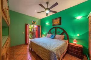 1 dormitorio verde con 1 cama y ventilador de techo en Casa Rodeo - Golden Zone Villa with Large Pool & Rooftop Ocean Views, en Bucerías