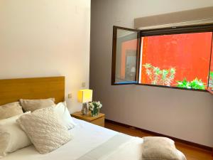 1 dormitorio con cama y ventana grande en CASA ANDAQUE con Aire Acondicionado, Parking y Patio en el Centro Histórico en Toledo