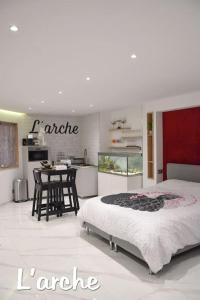 a bedroom with a large bed and a kitchen at L'Arche Loft nid douillet - Spa privatif in Grenoble