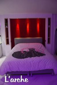 a purple bedroom with a bed with a purple headboard at L'Arche Loft nid douillet - Spa privatif in Grenoble
