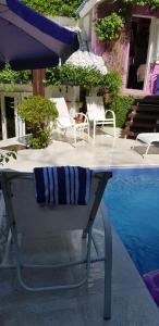 a table with a towel and an umbrella next to a pool at Morada das Flôres in Porto Alegre