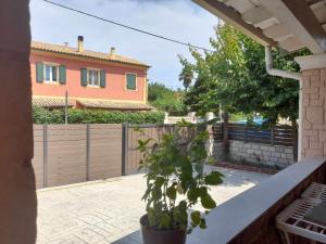 a house with a fence and a potted plant at Apricot garden in Kynopiástai