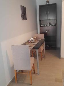 a dining room table with chairs and a kitchen at Apricot garden in Kynopiástai +7 photos