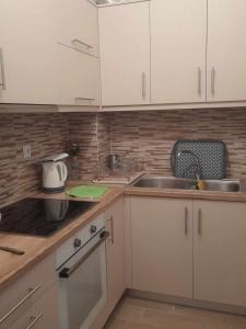 a kitchen with white cabinets and a sink at Apricot garden in Kynopiástai