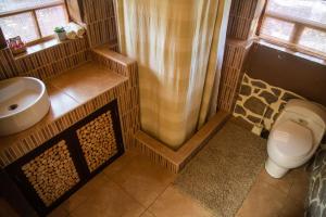 ein Bad mit einer Dusche, einem WC und einem Waschbecken in der Unterkunft Ayni Wasi in Coporaque