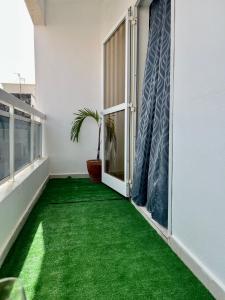 un balcón con alfombra verde en el suelo en The coolest room en Rufisque