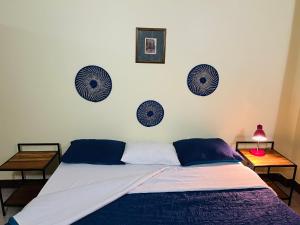 uma cama com lençóis azuis e brancos e duas mesas em Beckys Apartment in down Town Arusha 