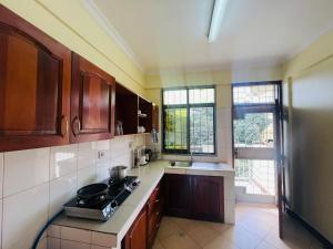 uma cozinha com armários de madeira e um forno com placa de fogão em Beckys Apartment in down Town Arusha 