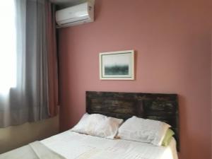 a bedroom with a bed and a picture on the wall at Apartamento Gonzaga in Santos