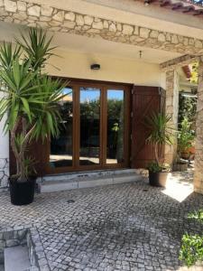 una casa con dos palmeras delante de una puerta en Villa Ávilla. Luxo e Charme., en Cascais