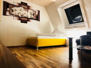 a living room with a yellow couch and a tv at Dream house in Künzelsau