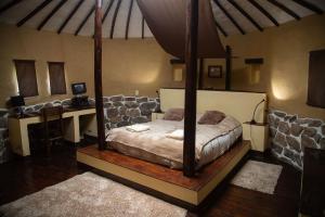 a bedroom with a canopy bed and a desk at Ayni Wasi in Coporaque