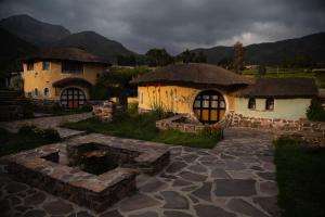 a couple of houses with a pond in a yard at Ayni Wasi in Coporaque