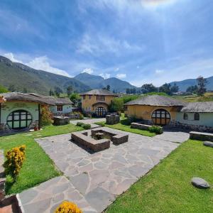 a garden with a stone patio and buildings at Ayni Wasi in Coporaque