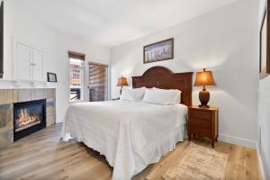 a white bedroom with a bed and a fireplace at Sundial Lodge 2 Bedroom by Canyons Village Rentals in Park City