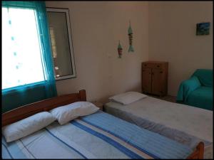 two twin beds in a bedroom with a window at Petrohori before midnight in Pylos