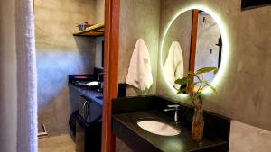 uma casa de banho com um lavatório e um espelho em Hospedagem Bangalô Patrimônio da Penha em Divino de São Lourenço