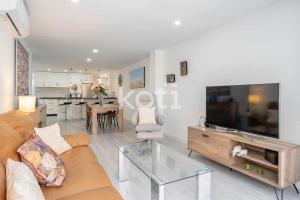 ein Wohnzimmer mit einem Sofa und einem TV in der Unterkunft Koti Rentals - Lubina 2 in Fuengirola