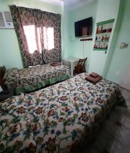 a bedroom with a bed with a floral comforter at La Rojarilla in San Miguel de Tucumán