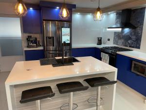 a kitchen with a white counter and blue cabinets at Luquillo Mar Paradise in Luquillo