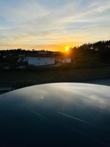 a view of the sunset from the top of a car at Reis House in Torre de Dona Chama