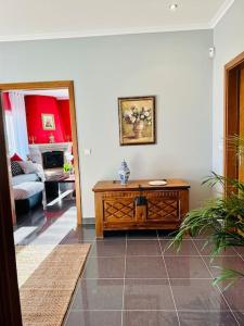 ein Wohnzimmer mit einem Tisch und ein Zimmer mit einem Sofa in der Unterkunft Reis House in Torre de Dona Chama