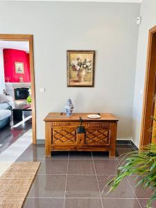 uma sala de estar com uma mesa de madeira num quarto em Reis House em Torre de Dona Chama