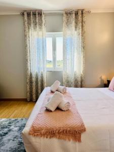 um quarto com uma cama com toalhas em Reis House em Torre de Dona Chama