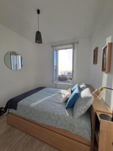 um quarto com uma cama e uma janela em Le Rayon Vert vue mer em Fécamp