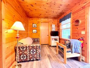 Habitación con cama, lámpara y TV. en Stargazers Cove Cottages Otter, en Middleton