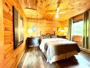 1 dormitorio con 1 cama en una pared de madera en Stargazers Cove Cottages Otter, en Middleton