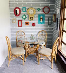 a glass table with four chairs and a clock on a wall at Cozy 3BR Home near Weeki Wachee in Spring Hill