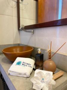 um balcão de casa de banho com um lavatório com toalhas e uma tigela em Recanto Maria Flor em Flecheiras