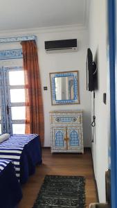 a room with a mirror and a bed and a window at Casa Familia in Chefchaouen