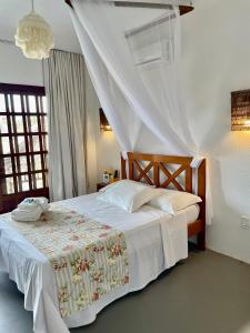 um quarto com uma cama de dossel branca em Recanto Maria Flor em Flecheiras