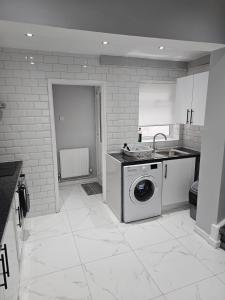 een keuken met een wasmachine en een wastafel bij Bridge Apartment in Liverpool