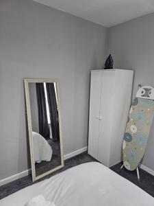 - une chambre avec un miroir, un lit et une commode dans l'établissement Bridge Apartment, à Liverpool