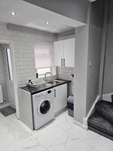 een keuken met een wasmachine en een wastafel bij Bridge Apartment in Liverpool