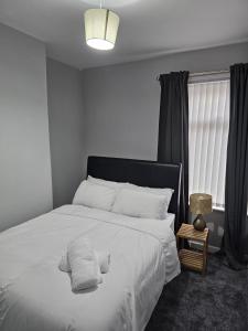 - une chambre avec un lit doté de draps et d'oreillers blancs dans l'établissement Bridge Apartment, à Liverpool