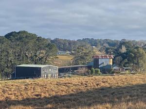 een boerderij met een schuur en een gebouw in een veld bij Tumbling Downs in Exeter