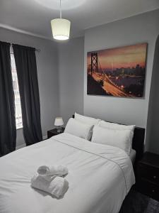 - une chambre avec un grand lit blanc et des serviettes dans l'établissement Bridge Apartment, à Liverpool