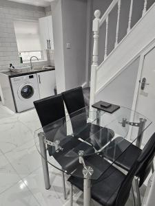 una mesa de cristal y 2 sillas en la cocina en Bridge Apartment, en Liverpool