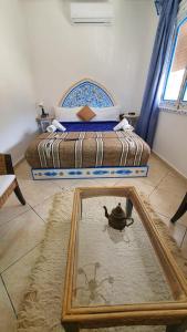 una camera da letto con un letto e uno specchio sul pavimento di Casa Familia a Chefchaouen